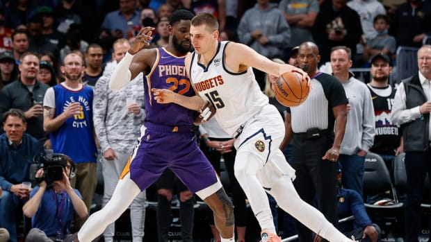 Mar 24, 2022; Denver, Colorado, USA; Denver Nuggets center Nikola Jokic (15) controls the ball as Phoenix Suns center Deandre Ayton (22) guards in the first quarter at Ball Arena. Mandatory Credit: Isaiah J. Downing-USA TODAY Sports